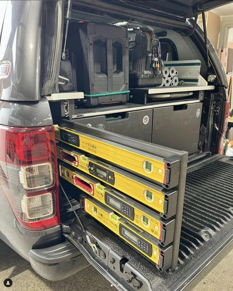 Universal level holder 2 pack with yellow levels stored securely in vehicle trunk, ideal for organized tool storage and easy transport.