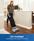 Person using Ultra Lightweight 14L Bagged Upright Vacuum Cleaner with LED Headlight and 2 Speed Settings on hard floor