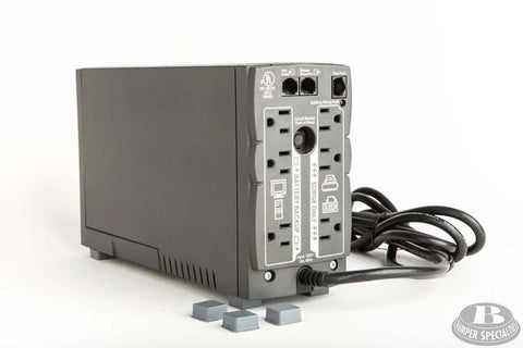 Back view of UPS with cables and four self adhesive bumper feet 0.780 in by 0.380 in black square polyurethane pads nearby