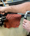 Hands using LubriMatic 30-800 Heavy Duty Mini Grease Gun w/ Pipe and Hose, Black/Silver, on machinery