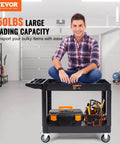 Man sitting on Heavy Duty 2 Shelf Utility Cart With 550 Lb Capacity And 360 Degree Swivel Wheels With Brakes in a garage