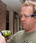 Man wearing UV Protection Safety Goggles With 99 Percent UV Impact Resistant Clear Lenses using a drill outdoors.