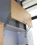 Vertical Swing Lift Up Stay Pneumatic for Cabinet Door installed, showcasing silver hinges and smooth arm mechanism in a kitchen cabinet.