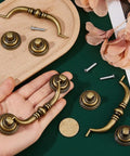 Set Of Six Vintage Bail Pull Handles In Antique Bronze Alloy For Cabinets And Drawers, decorative kitchen cupboard pulls displayed on table.