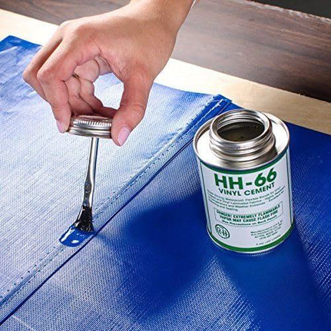 Applying HH-66 vinyl cement on blue patch from Ultimate DIY Pro Grade Vinyl Repair Patch Kit for Commercial Inflatables.