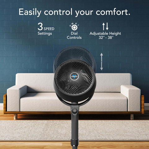 All Day Chill Pedestal Fan With Three Speed Control And Height Adjustable From 32 To 38 Inches Delivers Whole Room Air Circulation And Quiet Operation For Bedroom And Home By Vornado, shown in front of a couch in a living room setting.