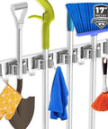 Wall Mounted Broom Holder With 4 Racks And 5 Hooks organizing broom, shovel, and tools in a garage or kitchen setting.