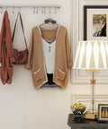 Wall with golden kitchen hanging racks, stainless steel rail holding 10 noiseless sliding hooks, featuring clothing instead of utensils.