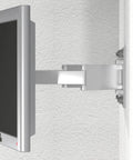Silver monitor mounted on a wall with adjustable arm bracket, side view.
