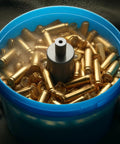 Front view of a blue plastic bucket filled with brass cartridge casings.