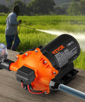 Water Diaphragm Pump, 12V DC, 5.5 GPM Flow, 70 PSI Rated Pressure (40-100 PSI Adjustable), 1/2" MNPT Self Priming Sprayer Pump with Pressure Switch for RV Camper Marine Boat Lawn, FCC Certified shown on a wooden surface with a field in the background.