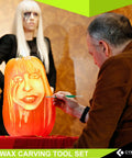 Man using Stainless Steel Spatula Wax And Clay Sculpting Tool Carver Set Pro Grade on a carved pumpkin.