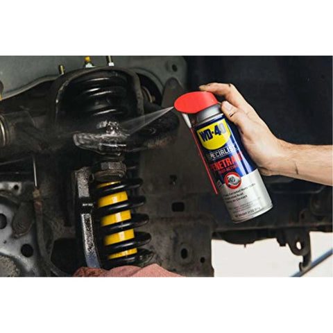 Applying WD-40 Specialist Penetrant with Smart Straw to metal car parts, showing 11 oz. can in use for fast-acting corrosion removal.