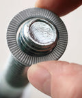 Close-up of Nord-Lock Wedge Locking Washer installed on 3/8 in bolt, zinc flake coating, used in high vibration settings.