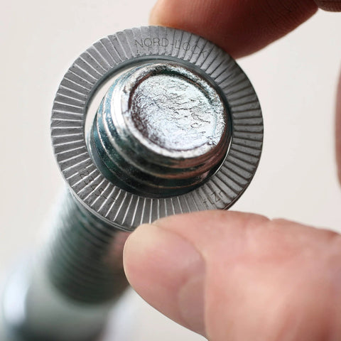 Close-up of Nord-Lock Wedge Locking Washer installed on 3/8 in bolt, zinc flake coating, used in high vibration settings.