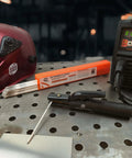 Aluminum E4043 Stick Electrode Rods for Welding, 1/8 Inch by 14 Inch, shown on metal table with welding helmet and machine