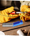 Close-up of a worker using a torch with a 13-Piece Stainless Steel Welding Tip Cleaner Kit with Aluminum Case nearby.