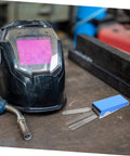13-Piece Stainless Steel Welding Tip Cleaner Kit With Aluminum Case on workbench next to welding helmet and torch nozzle.