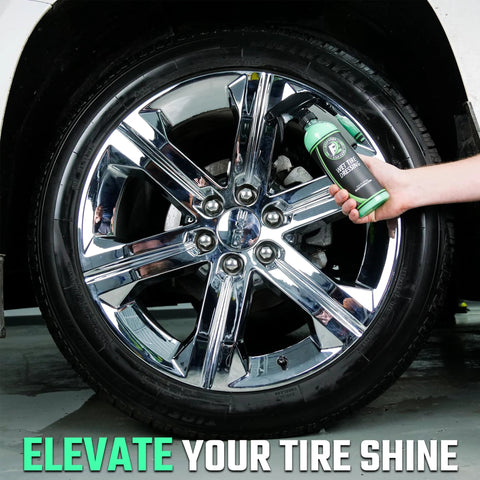 Hand holding Ultra Wet Tire Dressing Spray Delivers Extreme Shine With Non Greasy Silicone Formula near shiny car wheel.