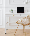 Modern office setup with white desk, laptop, gold wire chair, and adjustable furniture levelers for stable, balanced setups.
