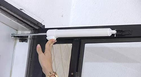 Hand installing Smooth - Dual Door Closer System - Heavy Duty on door, showcasing white, single-door unit for storm and security doors.