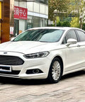 Ford Fusion 2013 white car parked in urban setting, showcasing sleek design and chrome front grille.