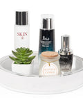 White 360 Degree Rotating Makeup Organizer With Perfume Tray, holding skincare, candle, and small potted plant, for dresser vanity.