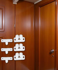 Three Pack White Marine Boat Door Catch Sets With Ball Roller Latches And Spring Back Plates on wooden paneling.
