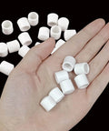 Hand holding several pieces from 25 Pack Door Stop Tips Caps 0.39 Inch White Rubber Universal Replacement Bumpers
