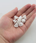 25 Pack Rubber Door Silencers in hand, half inch diameter, odorless silicone for metal doors, white, anti collision cushions