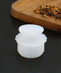 White Silicone Spiral Screw Thermal Sealed Stopper For Home Vacuum Flasks And Water Bottles on black surface next to spices.