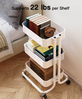 Three Tier Metal Rolling Utility Cart by Pipishell A Workhorse On Wheels With Two Lockable Wheels Great For Kitchen Dining Room And Living Room Storage And Organization Heavy Duty Mesh Shelves Mobile Serving Cart In White with books on tiers next to a couch.