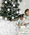Child playing near Christmas tree with Ball Pit Balls Phthalate Free BPA Free Non-Toxic Crush Proof Play Balls for Toddlers Kids