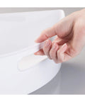 Hand holding the handle of Quarter Wedge Lazy Susan Turntable Organizer With Handle In White Made From Recycled Plastic For Pantry Kitchen Cabinet