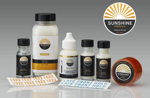 Assorted hair adhesive products from Sunshine including clear double sided wig tape for daily wear stays put three quarter inch by twelve yards premium hair adhesive roll for wigs hair systems lace bases skin bases poly perimeter on lace or monofilament bases made in USA