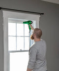 Person installing Window Insulation Kit With Rolled Shrink Film For Easy Indoor Installation Draft Blocking And Energy Savings.
