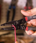Person using Kurve Wire Stripper Crimper Cutter Multi Tool for 10-26 AWG solid and 12-28 AWG stranded wire in a workshop.