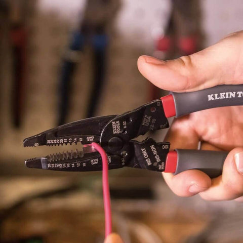 Person using Kurve Wire Stripper Crimper Cutter Multi Tool for 10-26 AWG solid and 12-28 AWG stranded wire in a workshop.