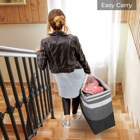 Woman carrying Two Pack Large Waterproof Freestanding Collapsible Laundry Hampers With Reinforced Handles 75 Liter Each Ideal For Laundry Room Dorm Bathroom And Bedroom Grey Durable Frame Makes Upright Use Easy And Tidy down stairs