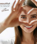 Smiling woman making heart shape with hands, Velona branding visible, promoting natural beauty, text reads 'You are beautiful when you're natural.'