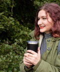 Person holding Double Wall Vacuum Insulated Travel Tumbler 20 Oz Keeps Drinks Hot Or Cold For Hours with Easy Grip Stainless Steel Cup