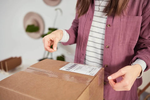 Person using HD Clear Packing Tape Dispenser Heavy Duty Tape Gun for Boxes Shipping and Moving Includes One Refill Roll Foam Handle