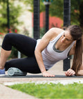 Woman using 12 Inch Foam Massage Roller With Softer Compression For Back, Body And Legs, Deep Tissue Recovery in outdoor setting