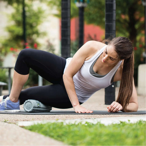 Woman using 12 Inch Foam Massage Roller With Softer Compression For Back, Body And Legs, Deep Tissue Recovery in outdoor setting