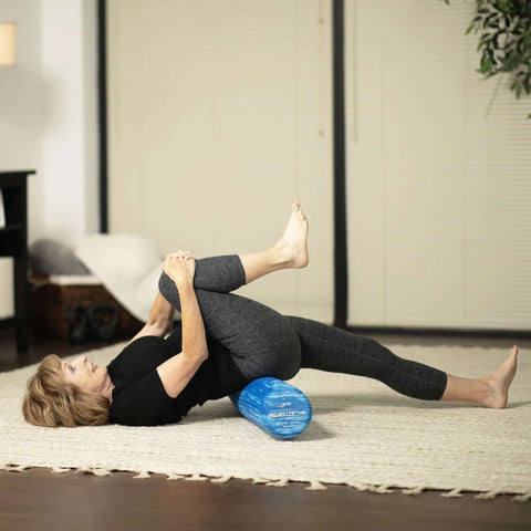 Person using Pro Roller Soft Density EVA Foam Roller For Physical Therapy Pilates Yoga And Muscle Recovery 36 Inch Blue for stretching.