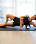 Woman using Medium Compression Foam Roller For Myofascial Release Massage With Three Texture Zones in exercise room