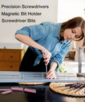 Woman using tools from the Pink 263-Piece Home Repair Tool Kit With Wide Mouth Storage Bag For DIY Projects And Breast Cancer Awareness Ribbon