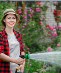 Person using a garden hose equipped with Garden Hose Quick Connect Fittings Set 3/4 Inch GHT Solid Brass Connectors watering plants.