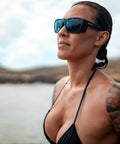 Person wearing sunglasses near a body of water.