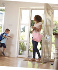 Woman and child entering a home with a two piece door silencer set cushions door impact, protects walls and hardwood floors visible on door.